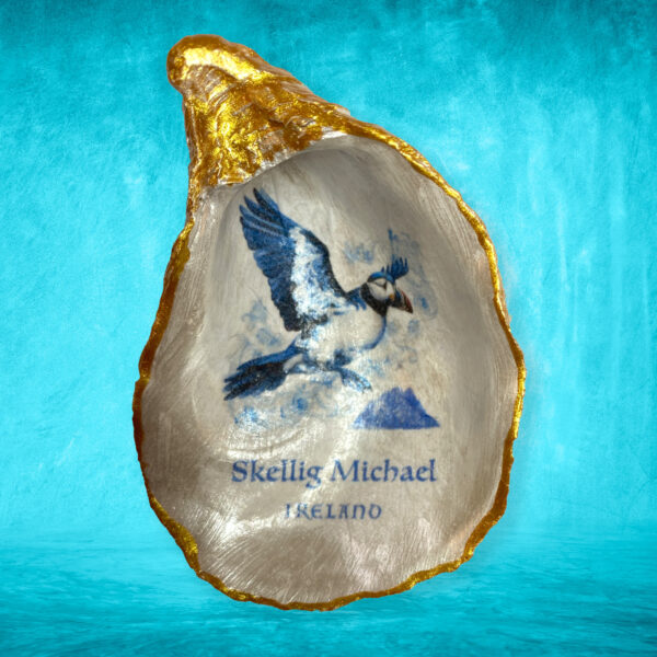 The design captures the Irish Puffin bird  (Delft Blue style illustration) fling over Skellig Michael.